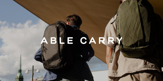 To personer med Able Carry-ryggsekker i et urbant miljø