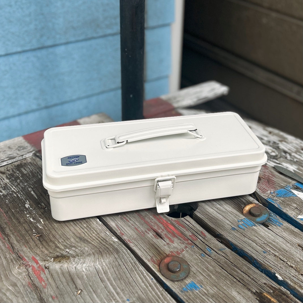 TOYO STEEL T-320 White, på et trebord ved et vindu